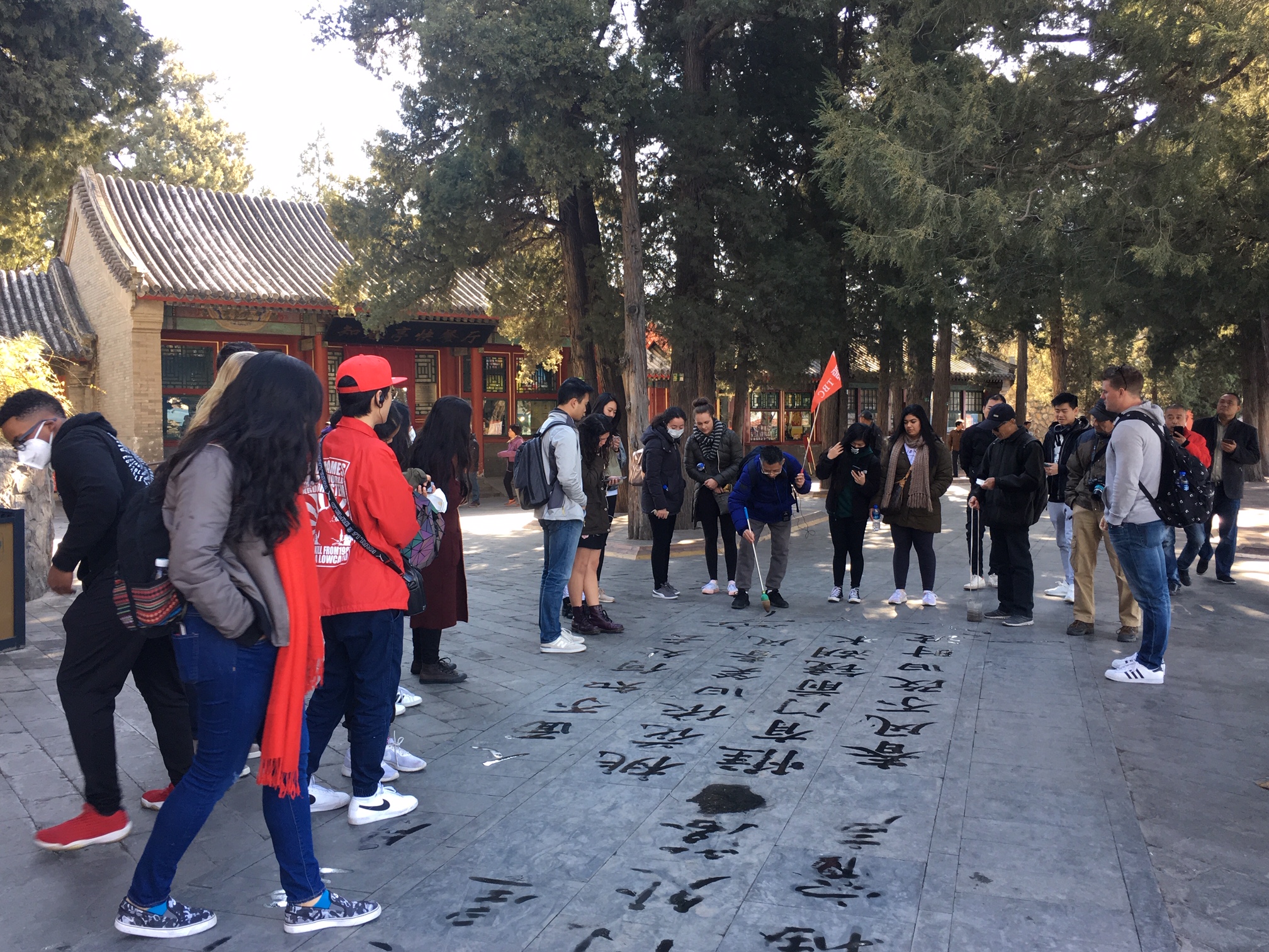 Students passing by a Chinese road with characters written on the path. 