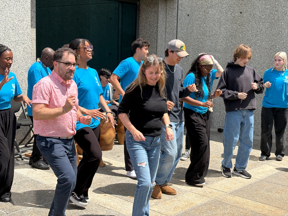 Students and faculty and staff dancing outside of university hall