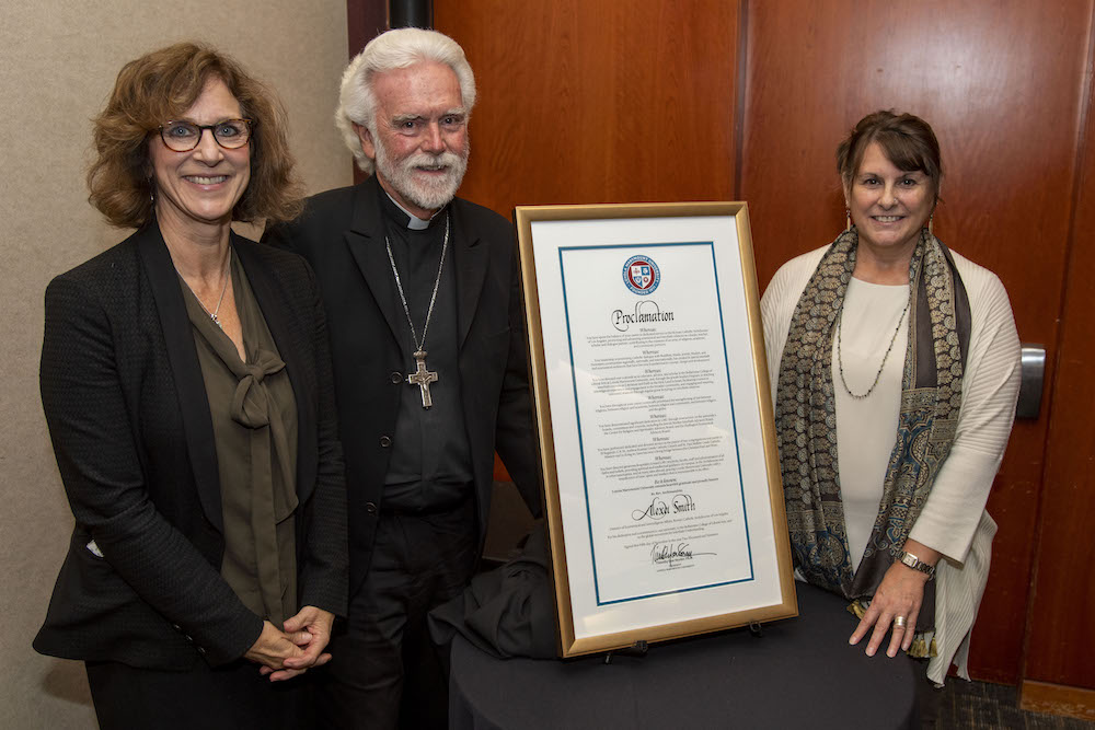 Father Alexei Smith poses with Dean Crabtree and Holly Levitsky