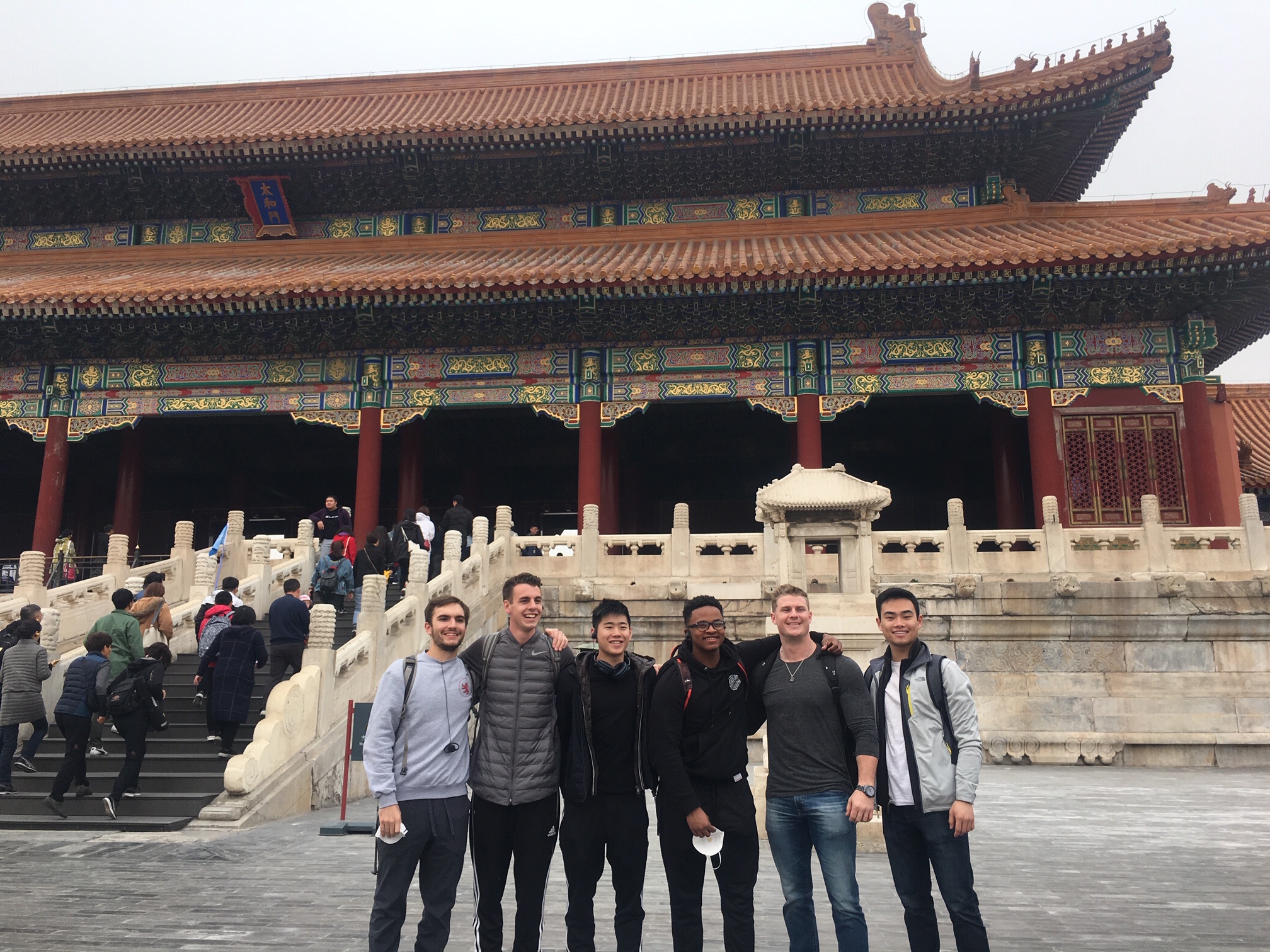 Students pose for photo in fron of Chinese architecture.