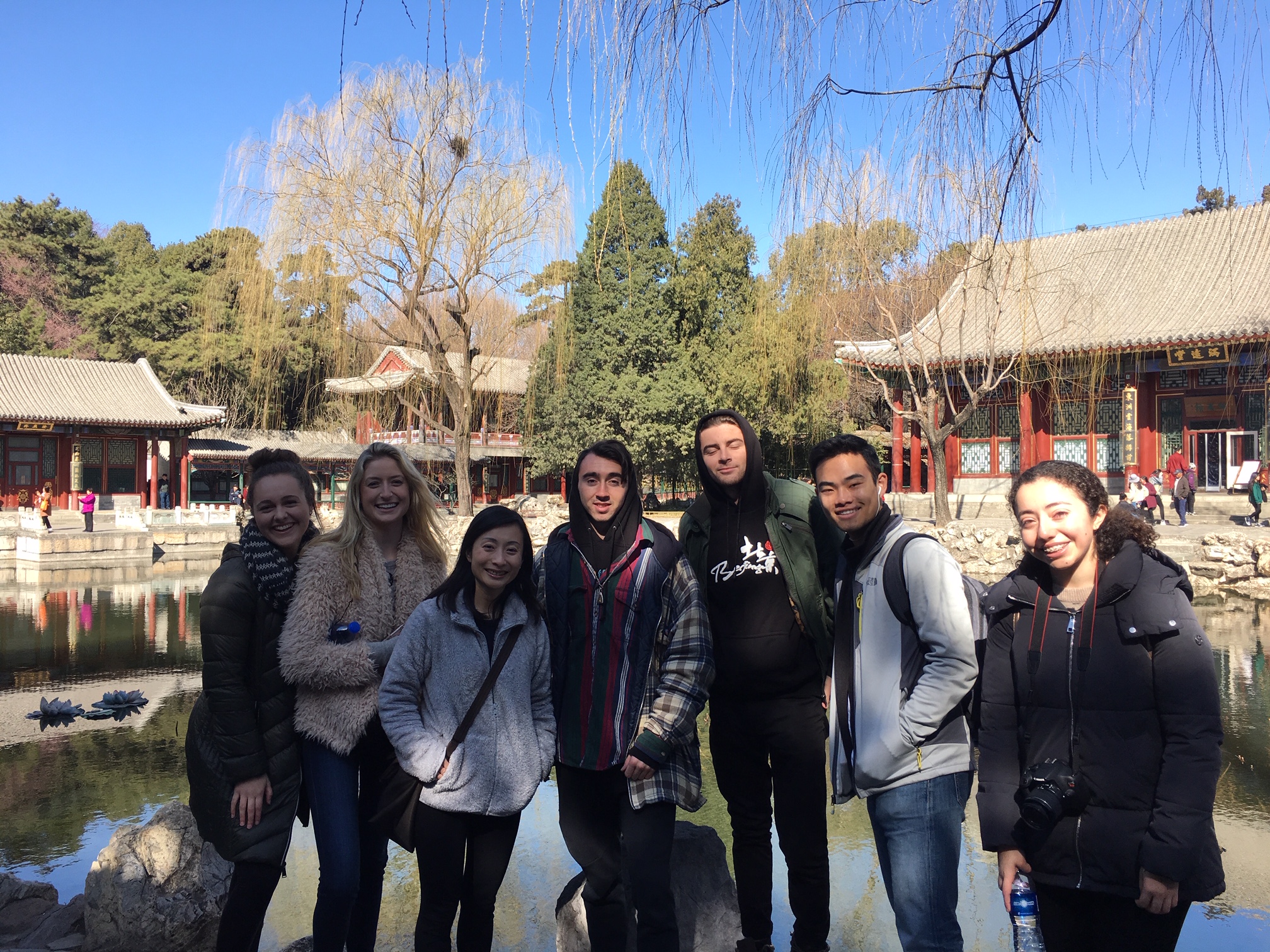 Students pose in front of Chinese scenery. 