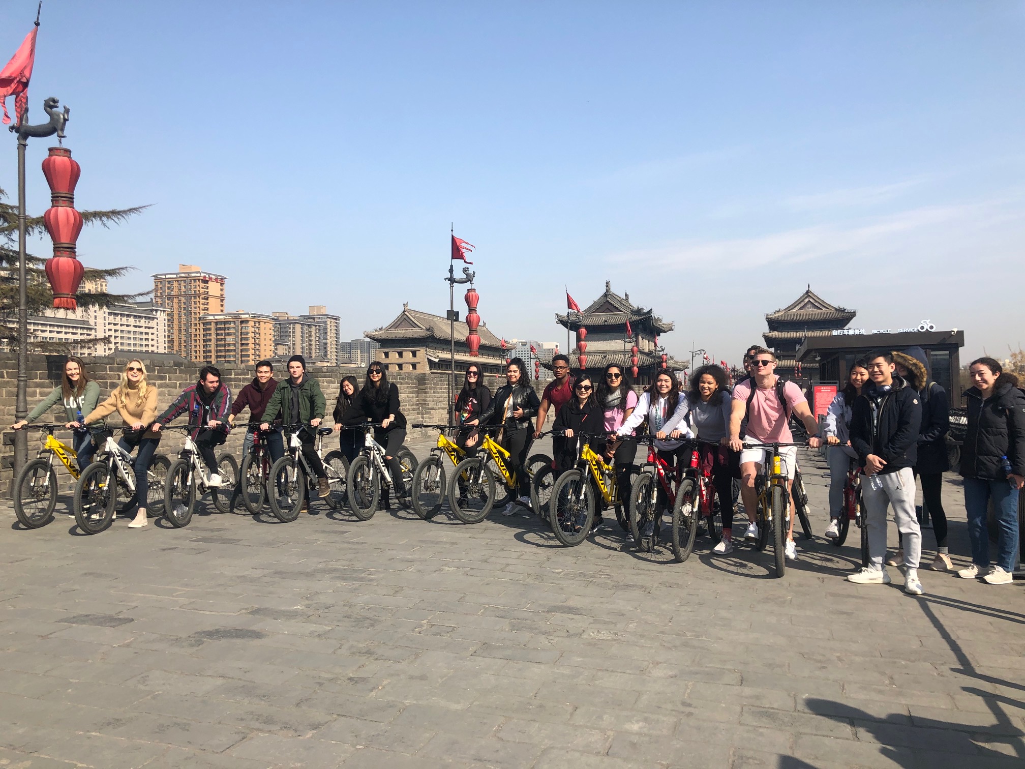 China immersion Students ride bicycles around an old city. 