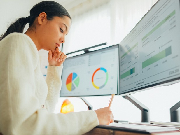Female student working on two screens displaying data