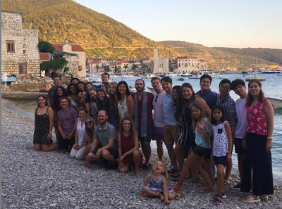 A group of students standing in front of a harbor