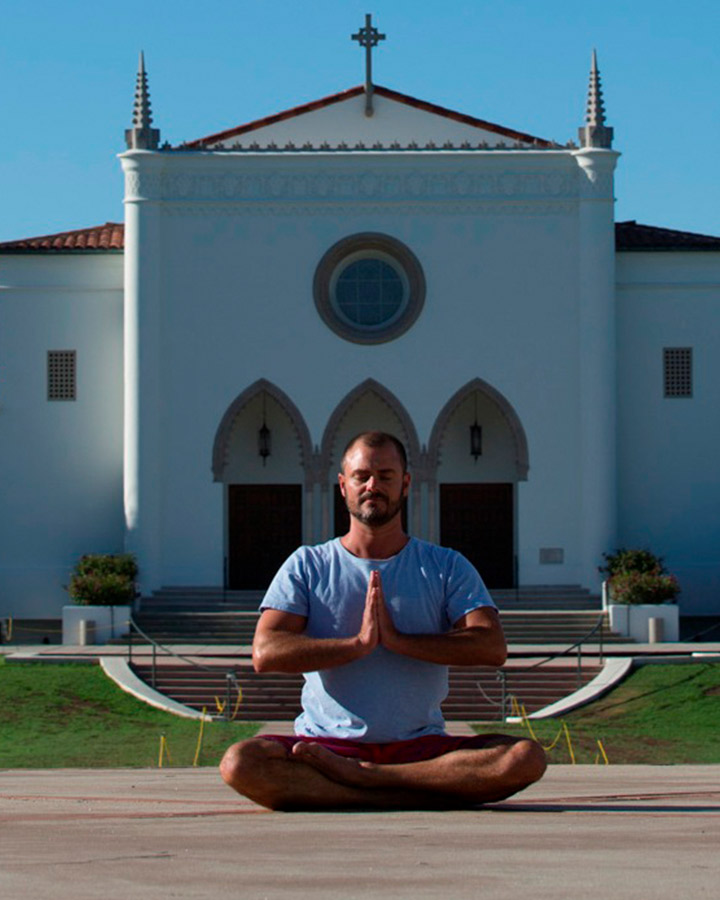 LMU Yoga Studies Alum Andre Haralyi doing yoga outside Sacred Heart Chapel