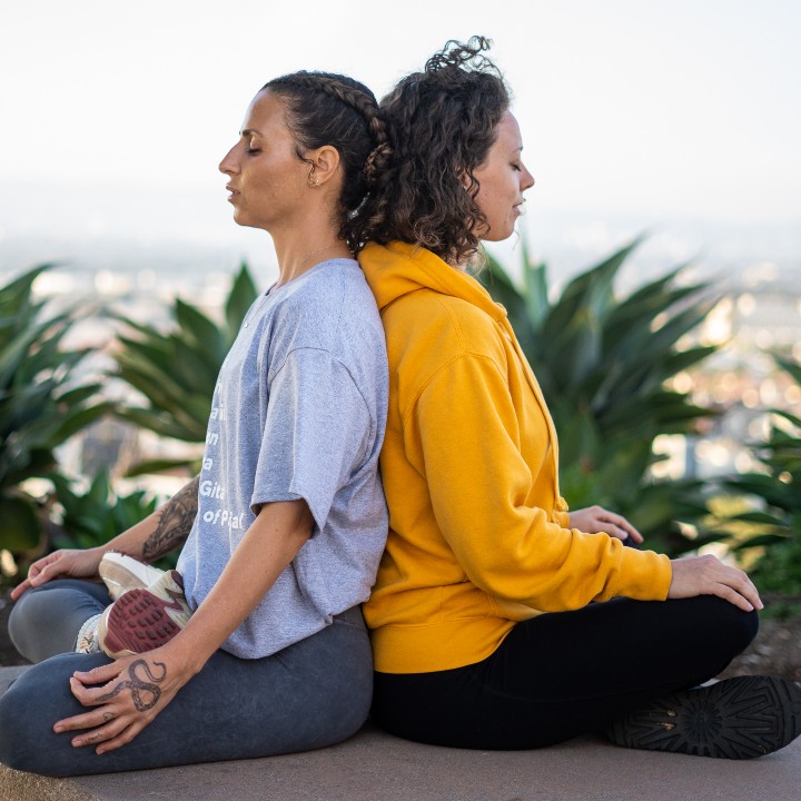 Two yoga students back to back on the bluff
