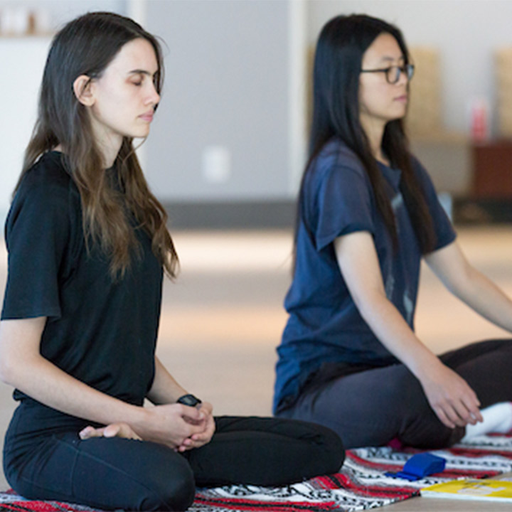Two women meditating in a yoga pose
